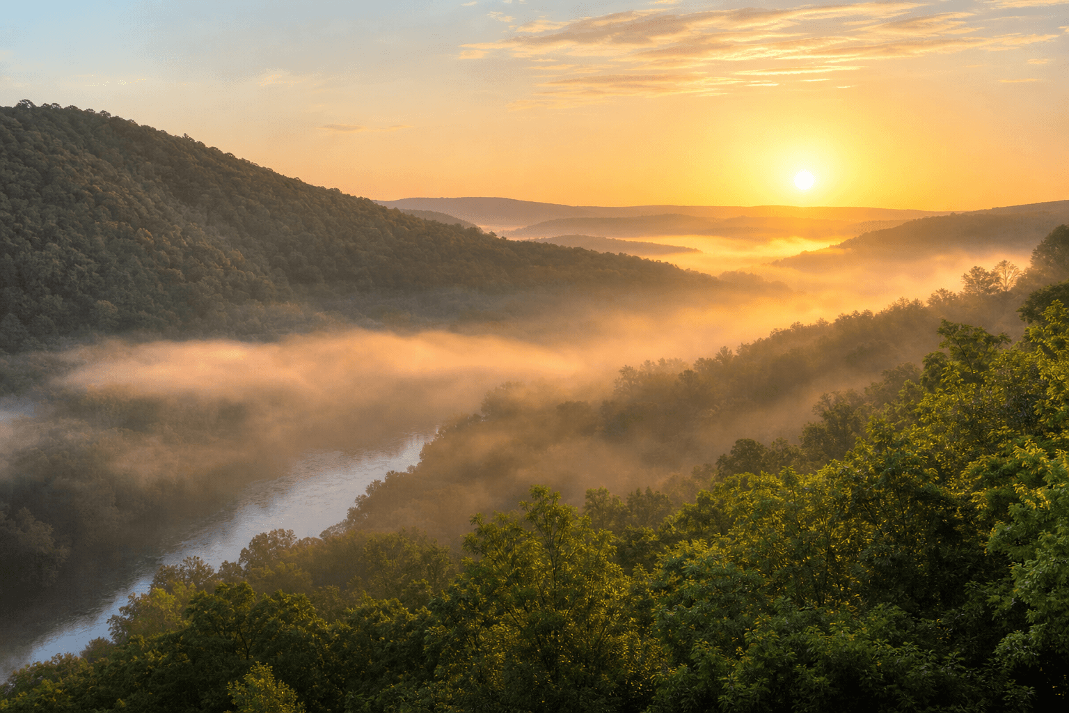 Arkansas Ozark Mountains at sunrise with misty river valley and green forested ridges
