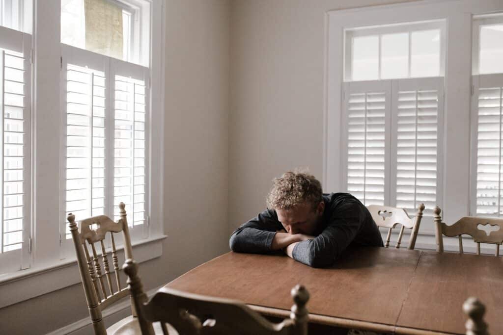 man laying his head down on a table