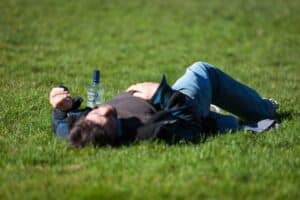 An alcoholic laying in a field