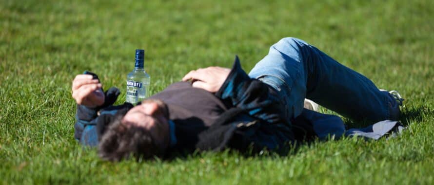 An alcoholic laying in a field